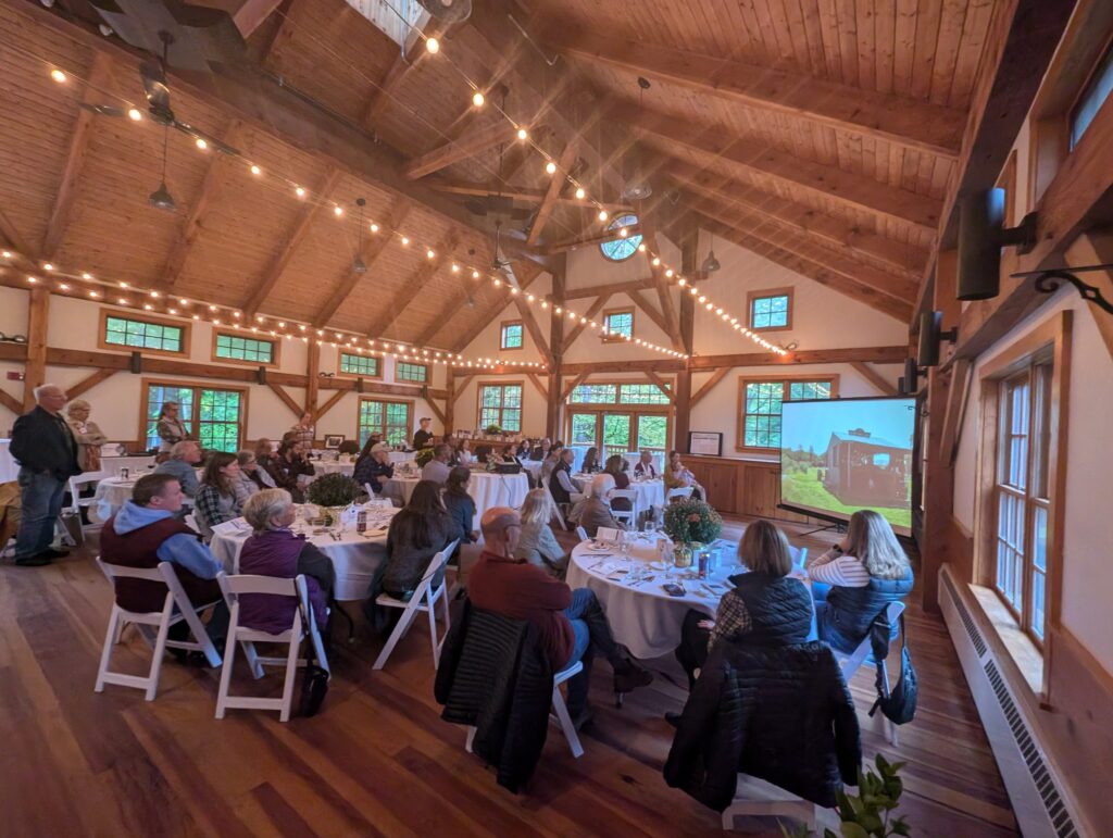 Event attendees watch Land For Good's new impact video.