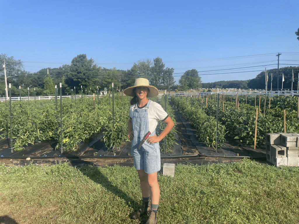 Daniela stands in front of her row crops on her leased farmland.