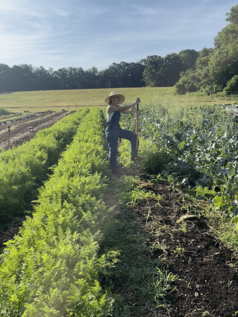 Daniela wears overalls and sun hat while prepping her row crops thanks to her secure lease.