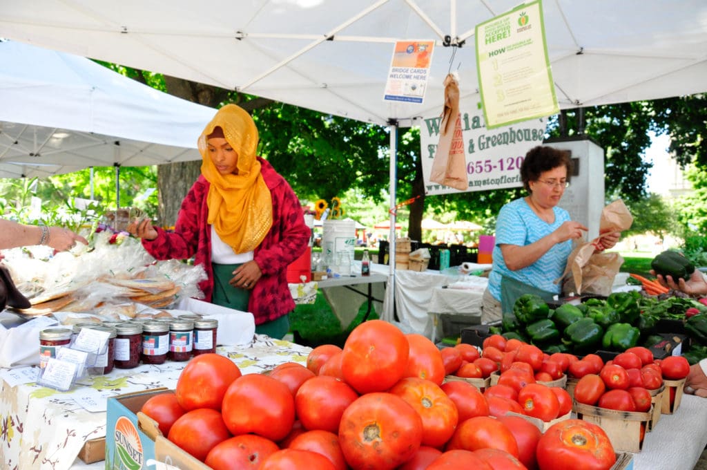 Farmers selling produce at farmers market credit USDA